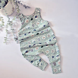 Toddler christmas day outfit. Bauble print dungarees on a light green background
