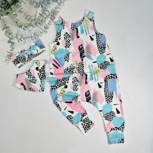 Colorful patterned romper with matching headband on a light gray background