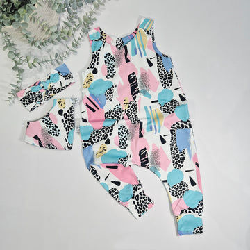 Colorful patterned romper with matching headband on a light gray background