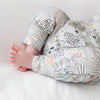 Baby's legs wearing a patterned outfit on a light background