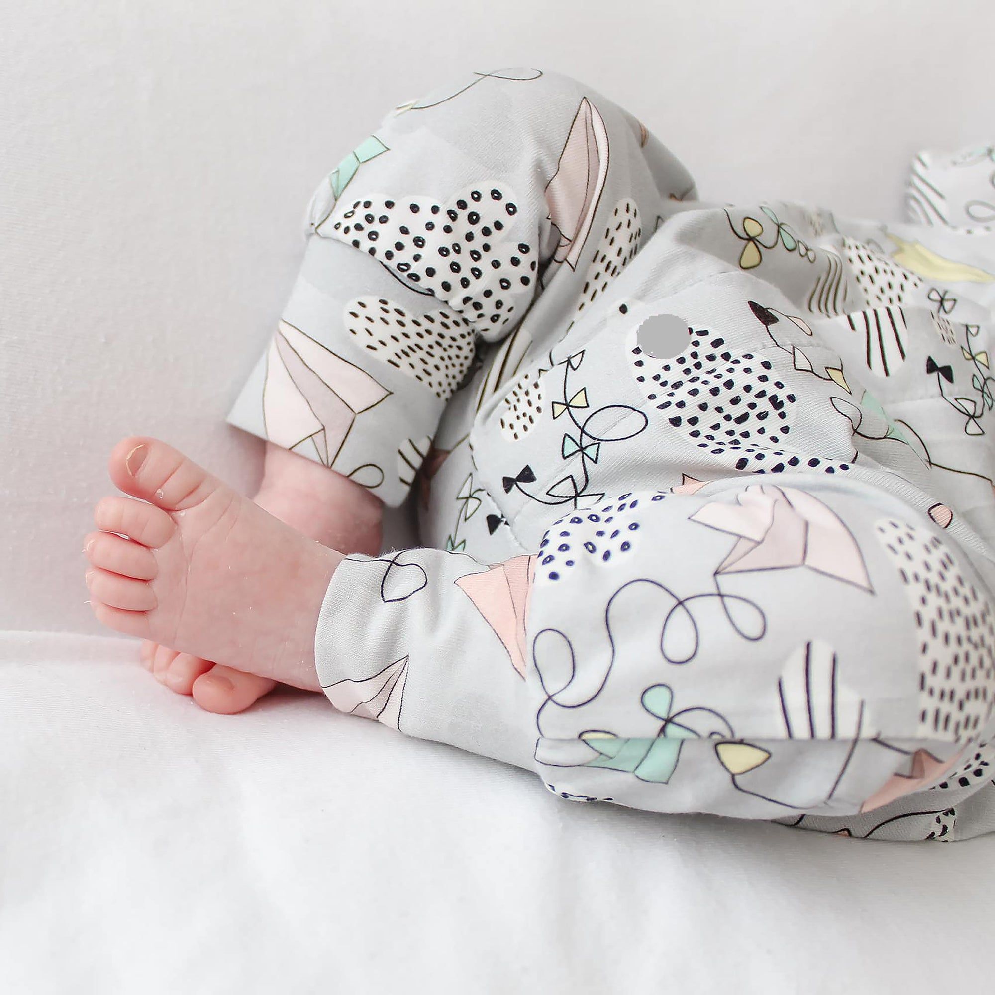 Baby's legs wearing a patterned outfit on a light background