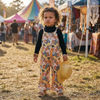 toddler girl wearing 70s aesthetic wide leg jumpsuit in a festival scene