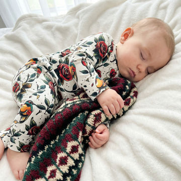 Sleeping baby wearing Tattoo Rose print babygrow