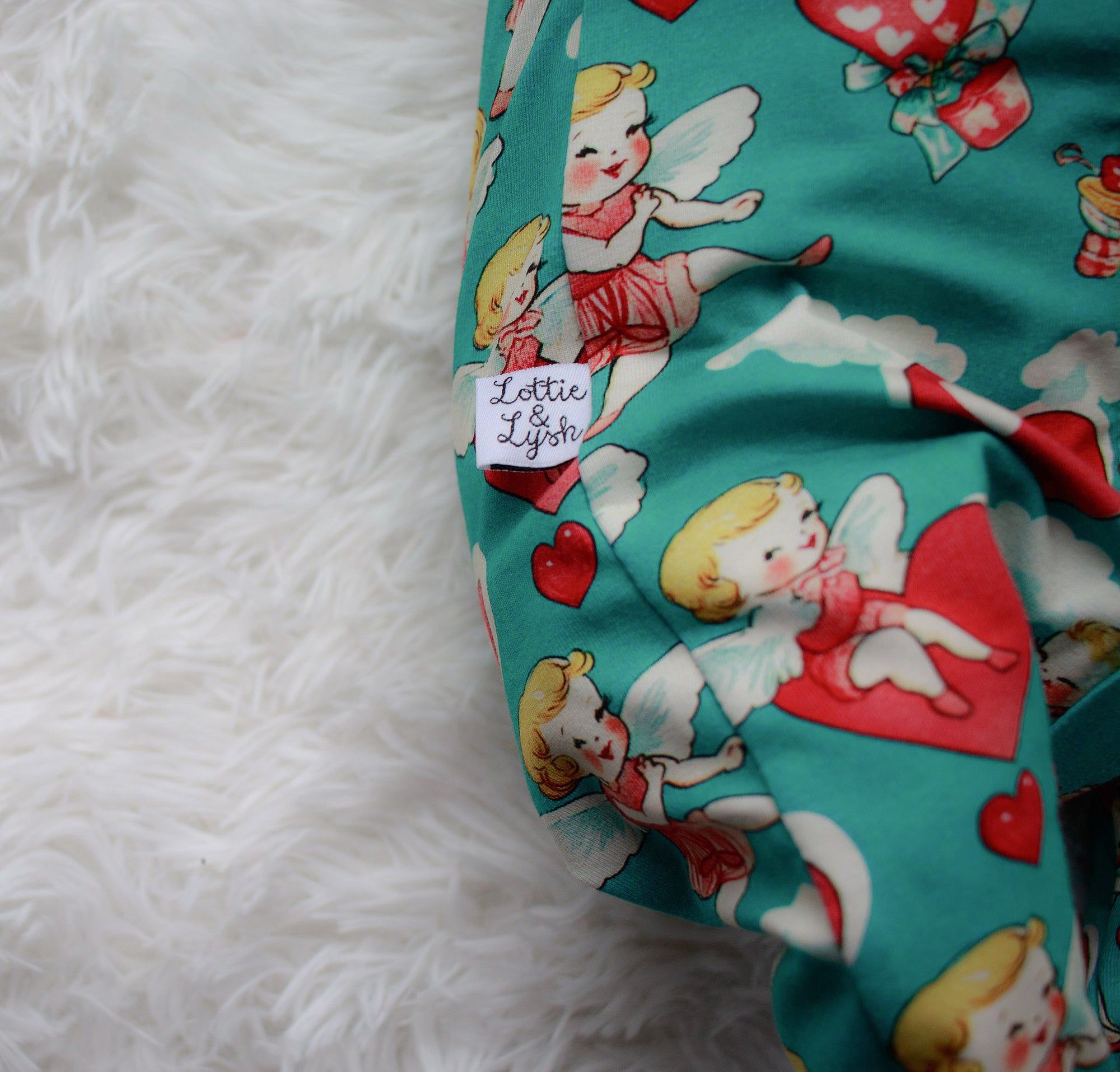 Close up of the Lottie & Lysh branding label on cherubs print babygrow