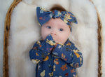 baby girl wearing winnie the pooh sleepsuit with matching headband