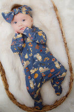 baby girl wearing blue winnie the pooh sleepsuit and matching headband