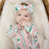 baby girl wearing christmas babygrow by Lottie & Lysh with matching bow headband
