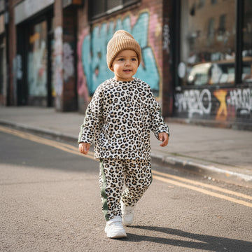Young trendy boy wearing leopard print tracksuit with brown beanie hat