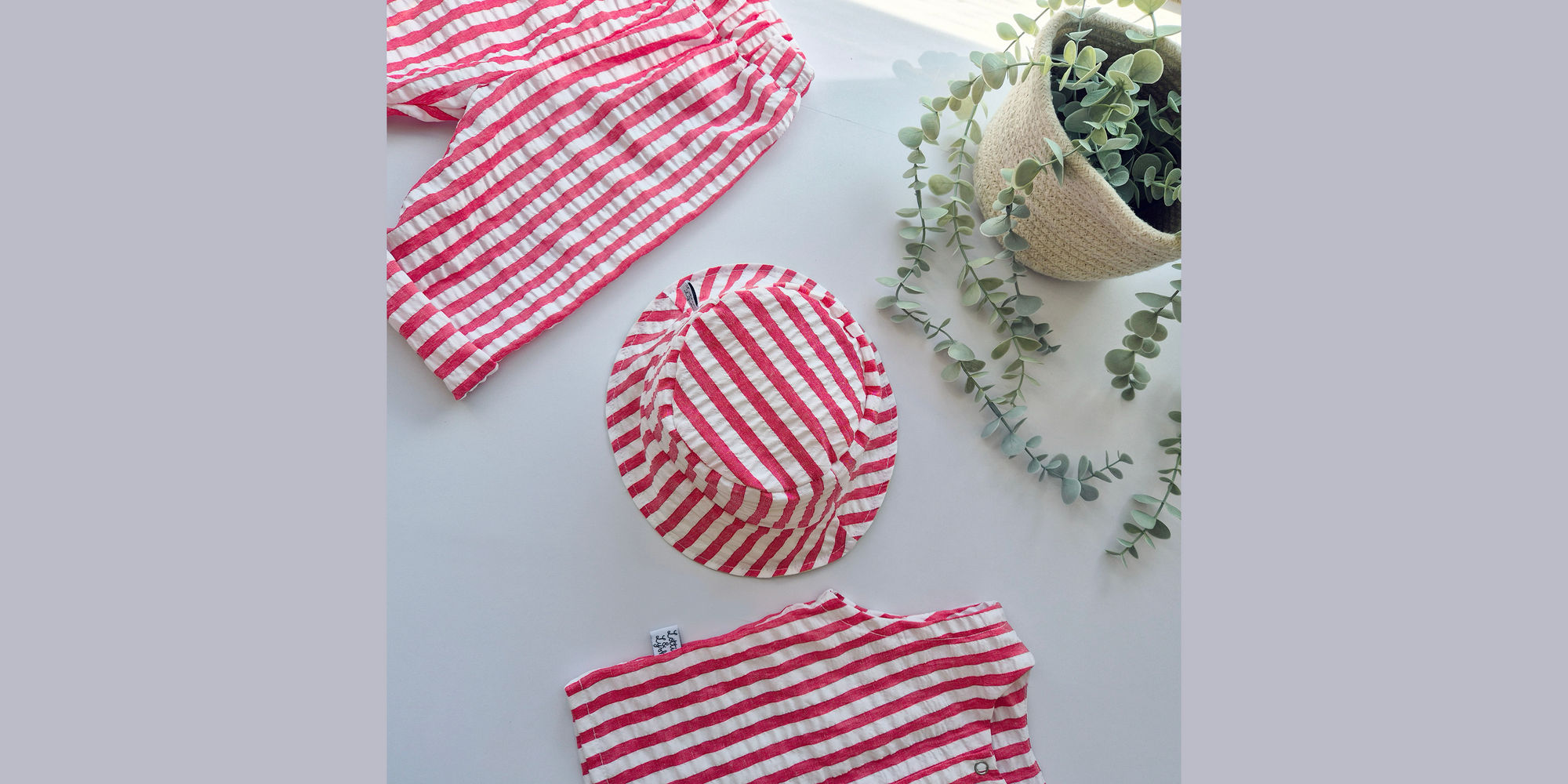 Lottie & Lysh New arrivals collection banner image. Featuring a red and white seersucker clothing set consisting of trousers, top and matching bucket hat. Ethically handmade by Lottie & Lysh in Cornwall, UK.