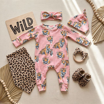 Tiger print babygrow on pink background with matching bow headband and hat
