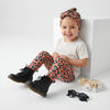 Toddler girl wearing Lottie & Lysh coral leopard print leggings with matching headband, white t-shirt and Dr Martens Boots.