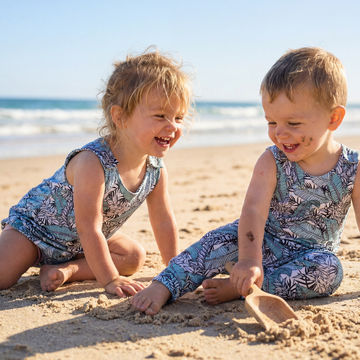 toddler boy and girl on the beach wearing matching leaf print outfits
