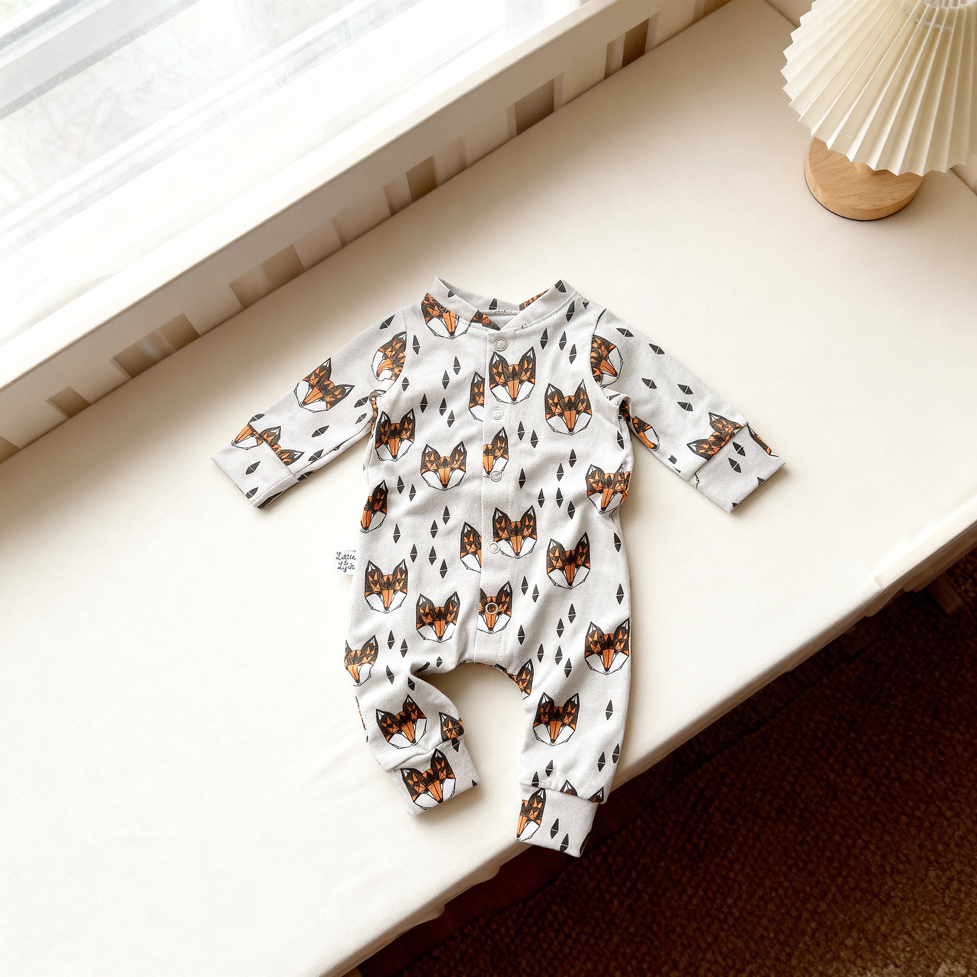 Baby romper with fox pattern on a white surface