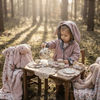 Little girl having a tea party in the woods with her toys. Wearing a Lottie & Lysh bunny jacket