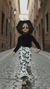 Trendy girl wearing bow print flares walking down the street