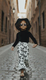 Trendy girl wearing bow print flares walking down the street