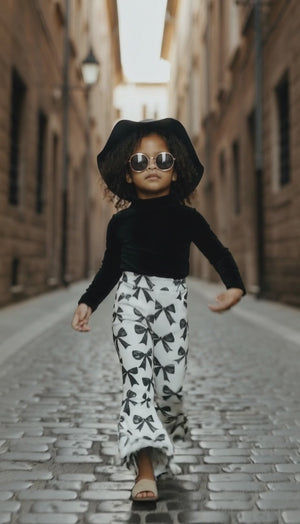 Trendy girl wearing bow print flares walking down the street