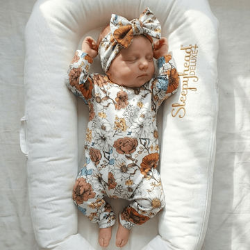 new baby girl wearing spring floral romper and bow set