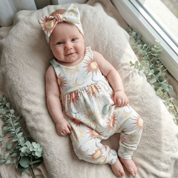 baby girl wearing summer solstice romper and headband set