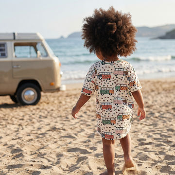 toddler on the beach wearing camper print sun dress
