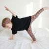 Toddler wearing coral leopard print leggings and headband. Styled with a black oversized t-shirt.