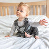 cute baby boy wearing Lottie & Lysh elephant printed dungarees whilst smiling at the camera