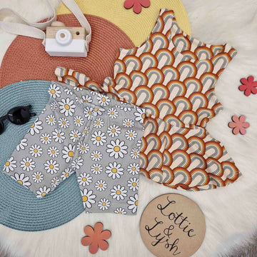 Retro rainbows peplum vest with daisy print cycling shorts. Kids flatlay image by Lottie & lysh