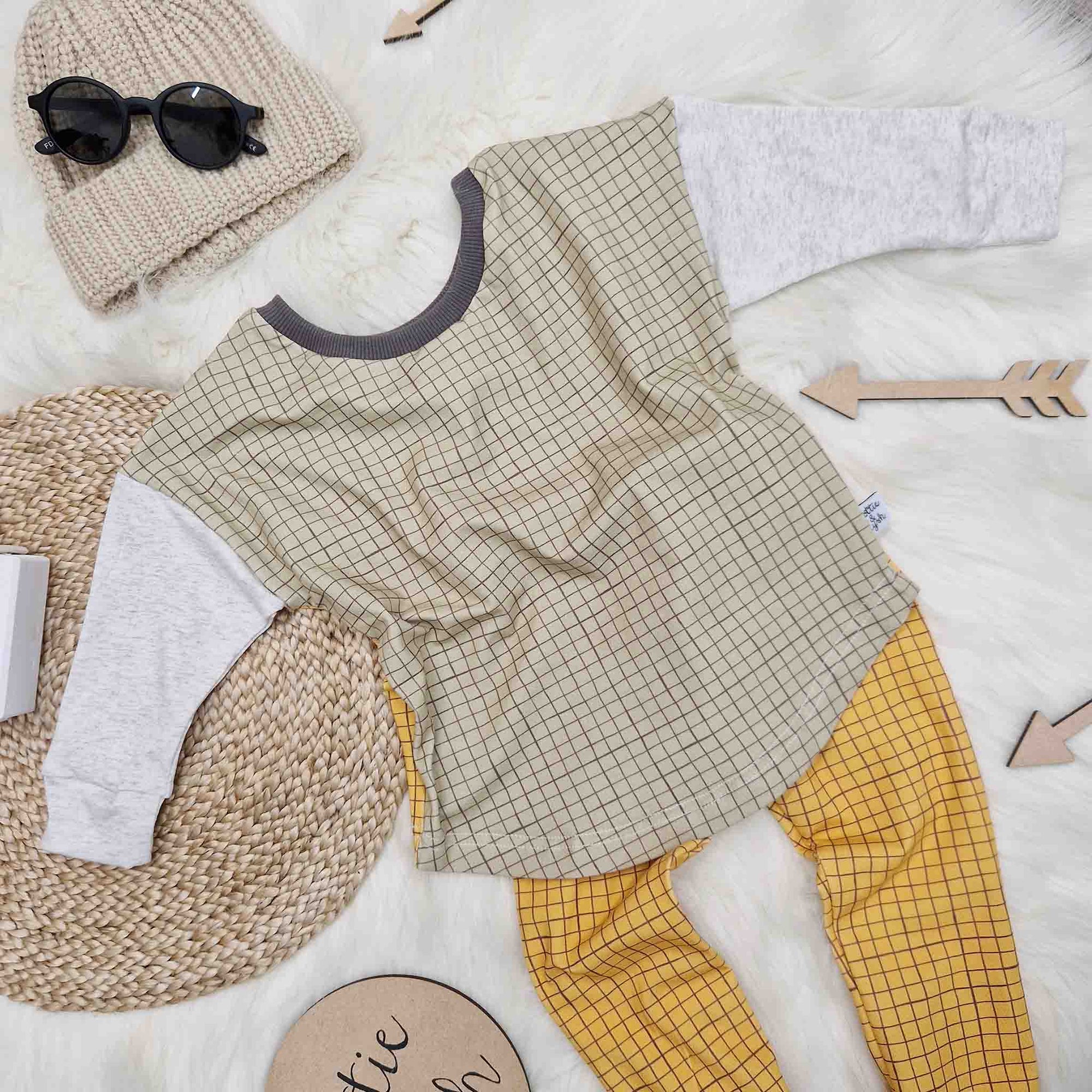 close up of the lottie and lysh sage grid 2-way top and mustard grid leggings