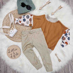 Kids outfit flat lay image featuring Lottie & lysh sage grid leggings, retro smiley oversized sweatshirt and green knitted beanie hat
