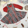 Baby girl's Christmas flatlay featuring a green tartan dress and matching red top