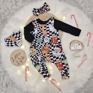 christmas print baby and toddler dungarees featuring black and white background with hipster santa elements. Photographed with a matching headband and bib