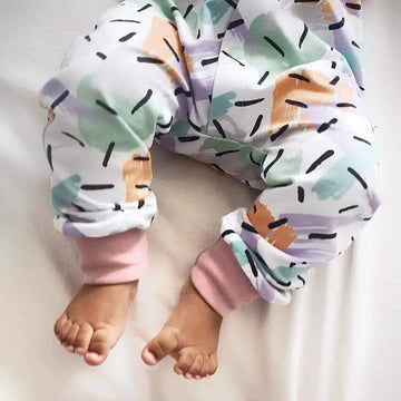 Baby girl wearing organic confetti frill should romper handmade by Lottie & Lysh UK