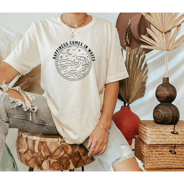 Women's surf t-shirt made in Cornwall by Lottie and Lysh. Cream t-shirt with "Happiness Comes in Waves" surf slogan