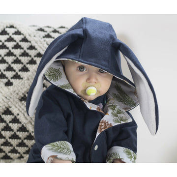baby boy wearing lottie & lysh unisex bunny coat in navy wool and festive leaves print