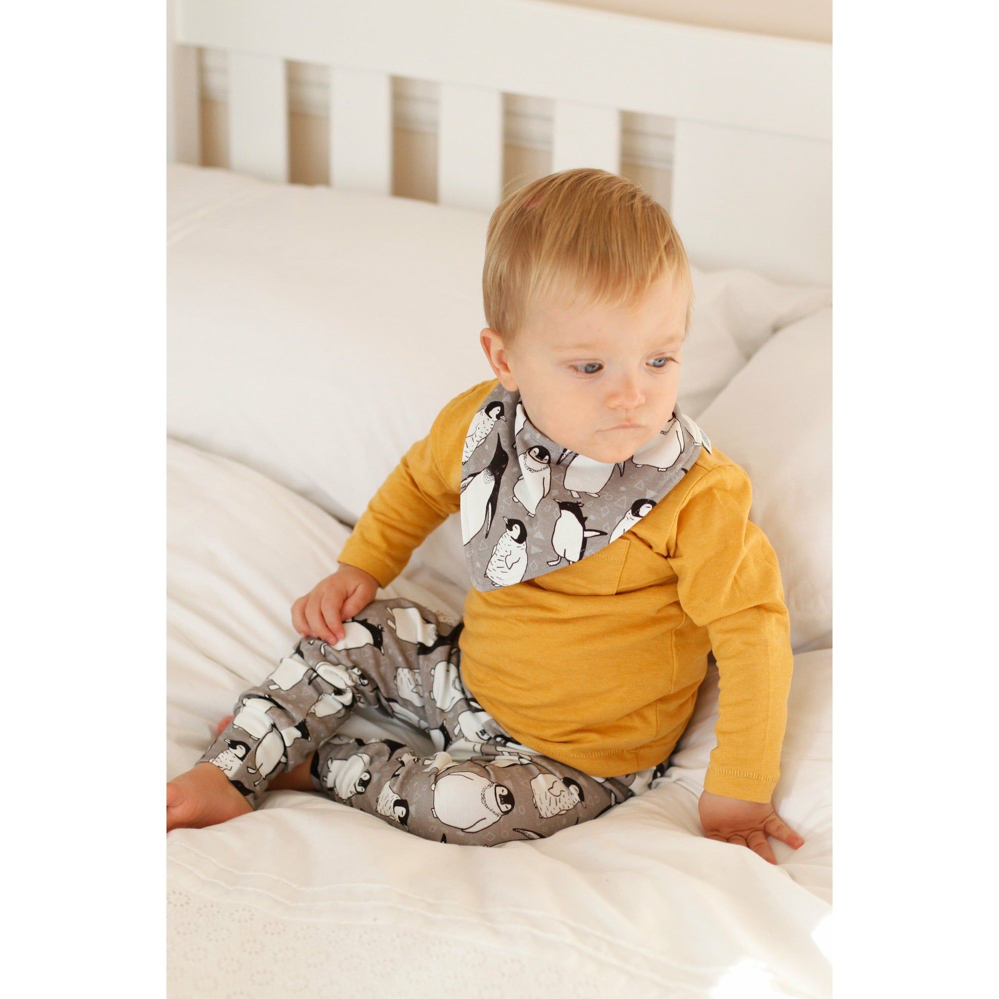 penguin print bandana bib and matching baby leggings paired with a long sleeve mustard top modelled by a