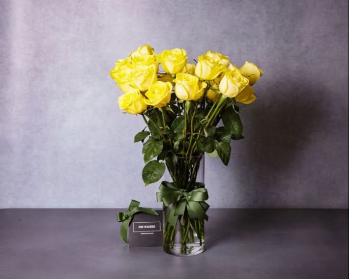 long stemmed yellow roses in a vase