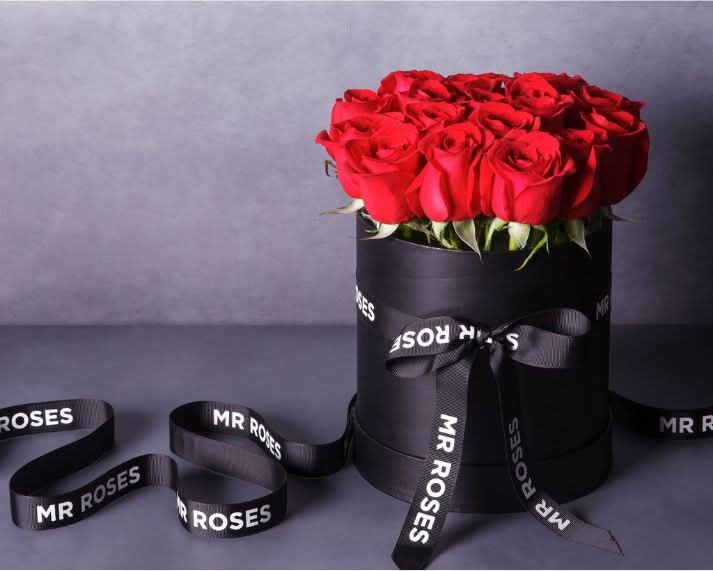 fresh red roses in an elegant black hat box