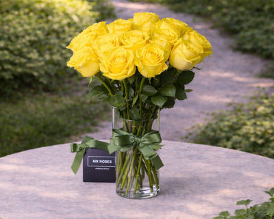 medium stemmed yellow roses in a vase