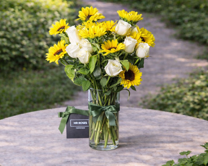 Sunflowers and white roses flower arrangement in vase 