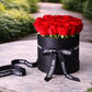 fresh red roses in an elegant black hat box
