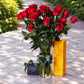 Long stem red roses in a glass vase beside a Veuve Clicquot champagne gift box