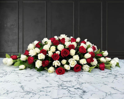 funeral spray of red and white roses, funeral flowers and casket flowers in white