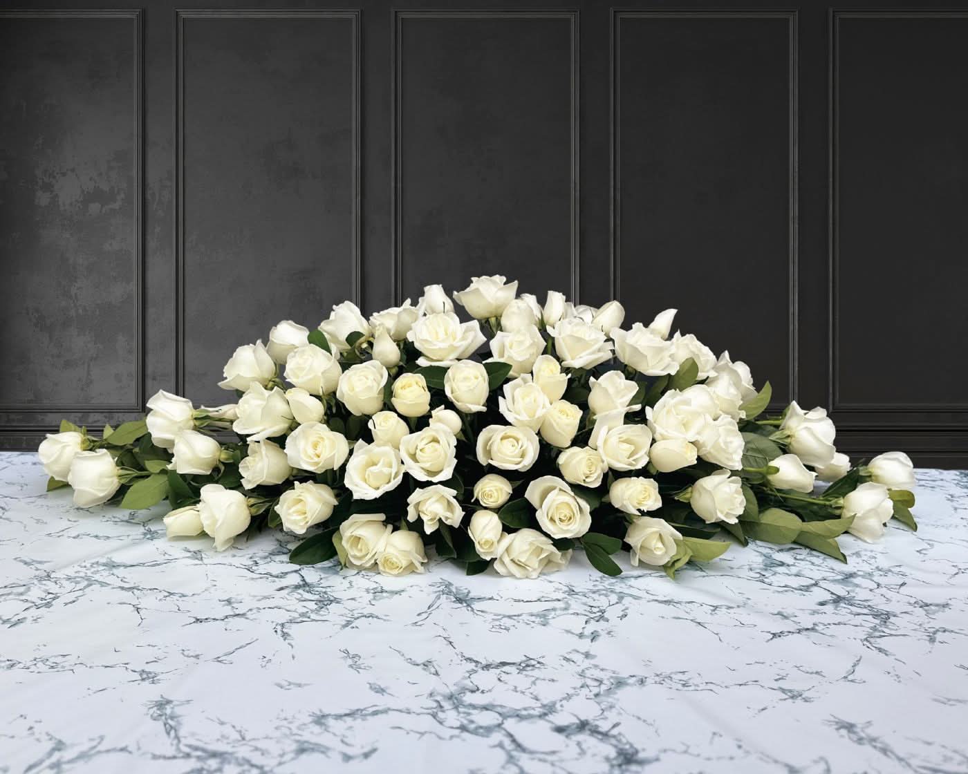 funeral spray of white roses, funeral flowers and casket flowers in white