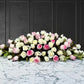 funeral spray of pink and white roses, funeral flowers and casket flowers in white