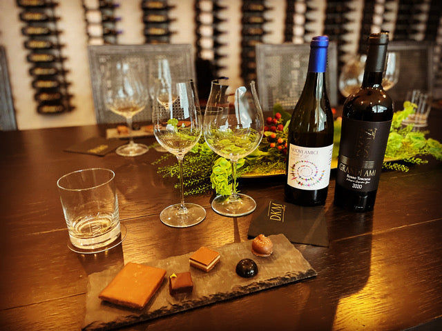 A table with wine glasses and chocolates on it.
