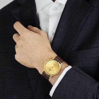 Herrenuhr mit braunem Lederarmband und goldfarbener runder Anzeige am Handgelenk