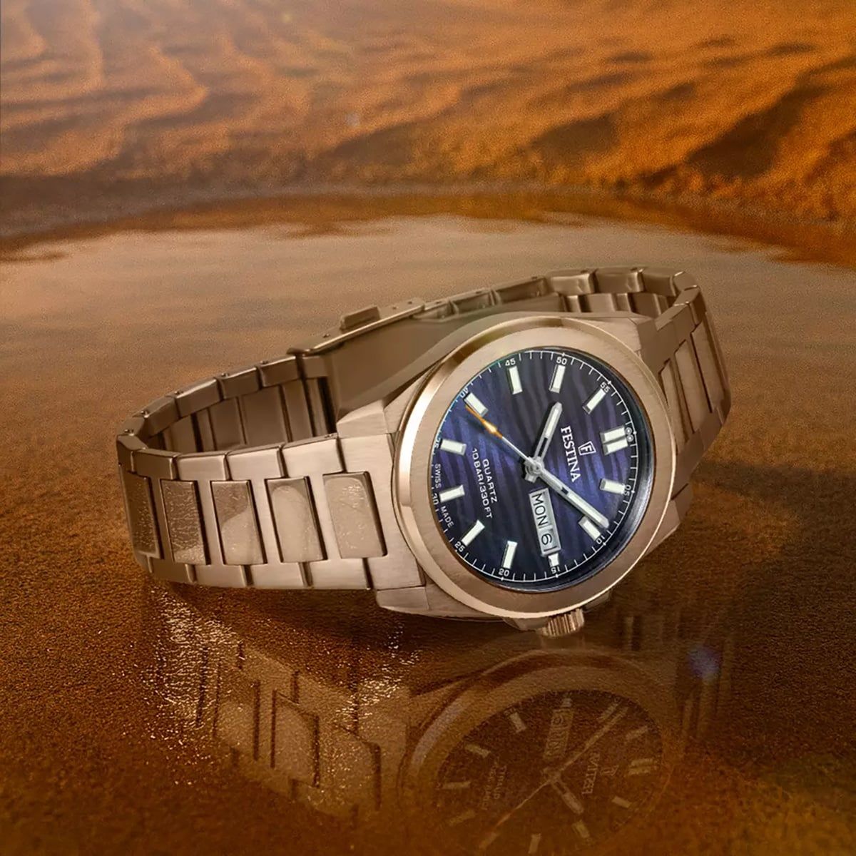 Herrenuhr mit blauem Zifferblatt und Edelstahlarmband auf einer Oberfläche.