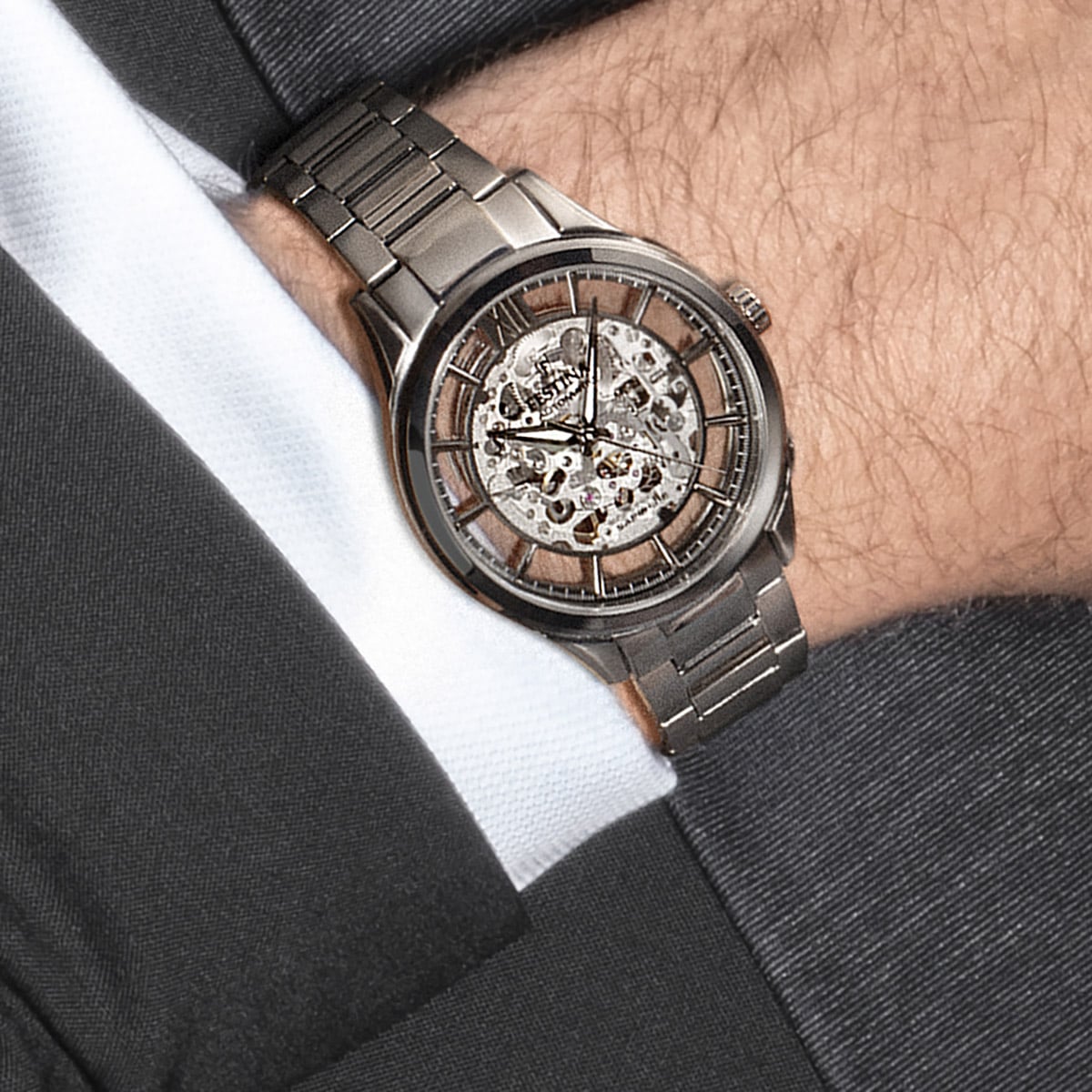 Herrenarmbanduhr am Handgelenk mit offenem Automatikwerk und silberfarbenem Ziffernring