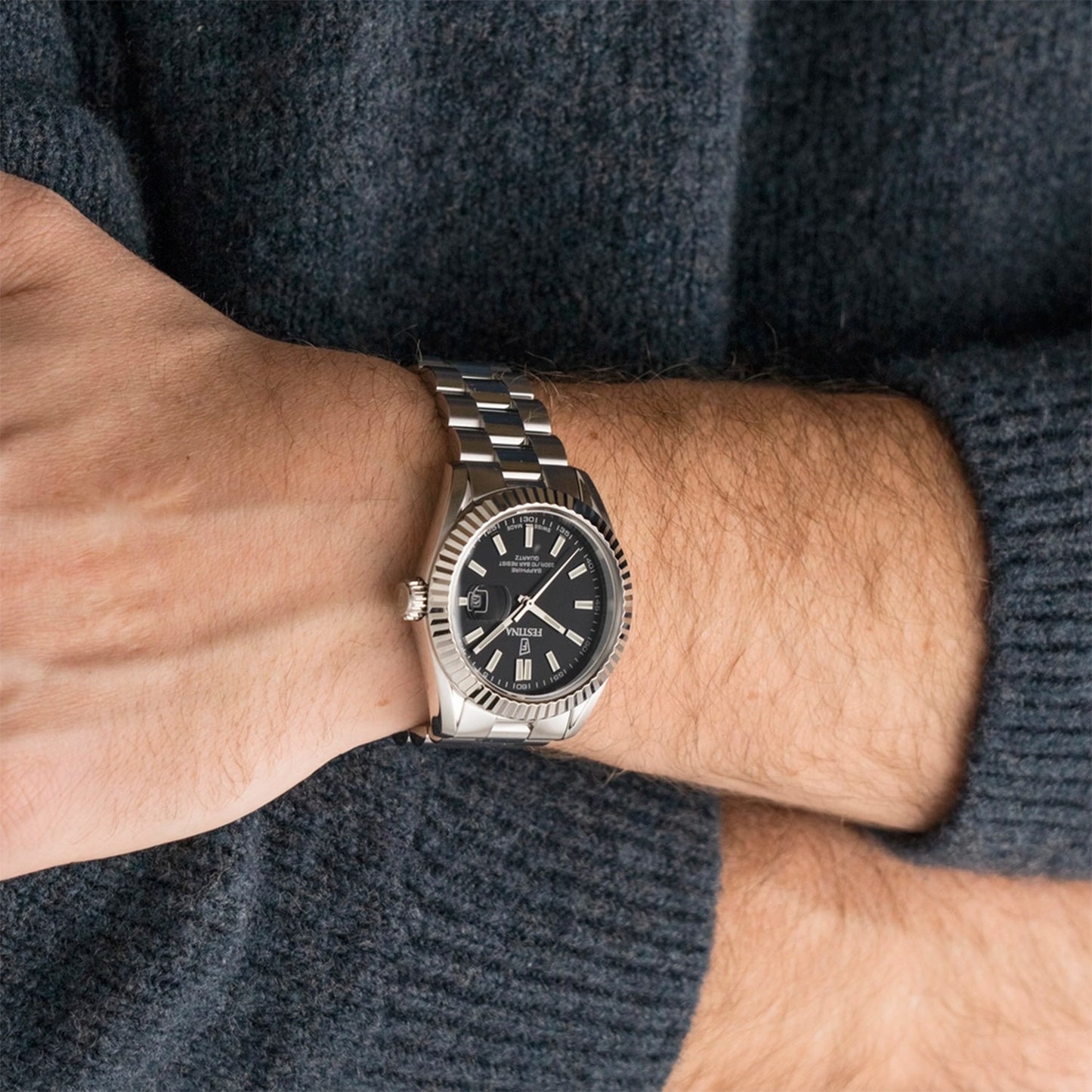 Herrenarmbanduhr am Handgelenk mit silbernem Edelstahlband und schwarzem Zifferblatt