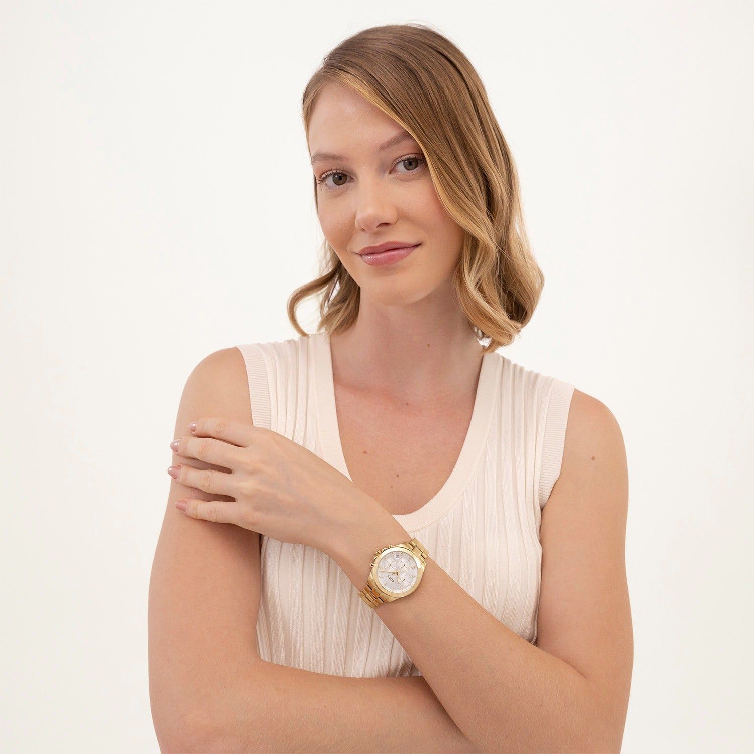 Damen-Armbanduhr am Handgelenk, goldfarbenes Metallband und weißes Zifferblatt